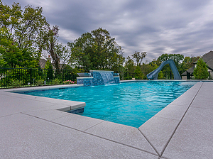 st. louis custom designed geometric concrete pool with cantilever coping, raised tiled wall with sheer descent and slide