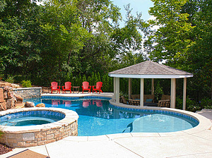 st. louis custom designed freeform concrete pool with raised concrete spa, tan shelf, raised wall, gazebo structure and red patio furniture